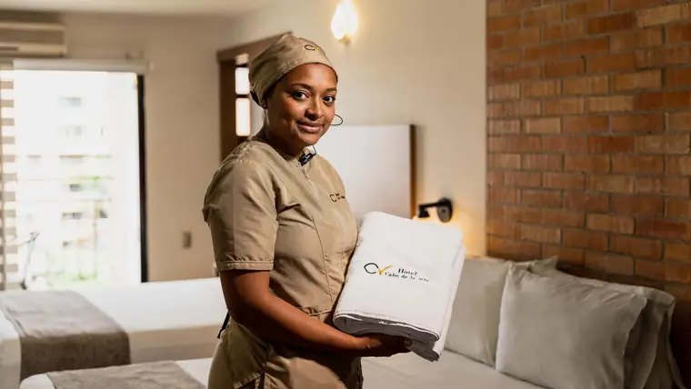 Housekeeper with towels in a hotel room